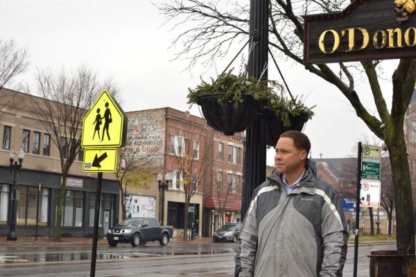 Man in front of crosswalk sign 