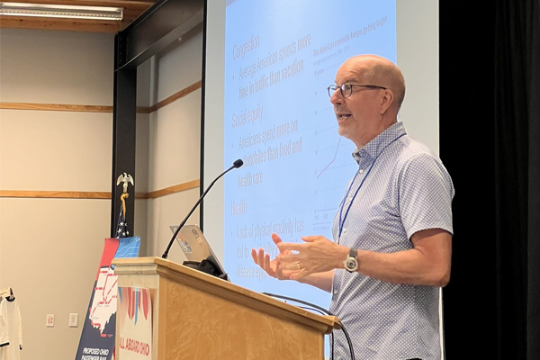 CURA Director, Harvey Miller, speaking at a podium